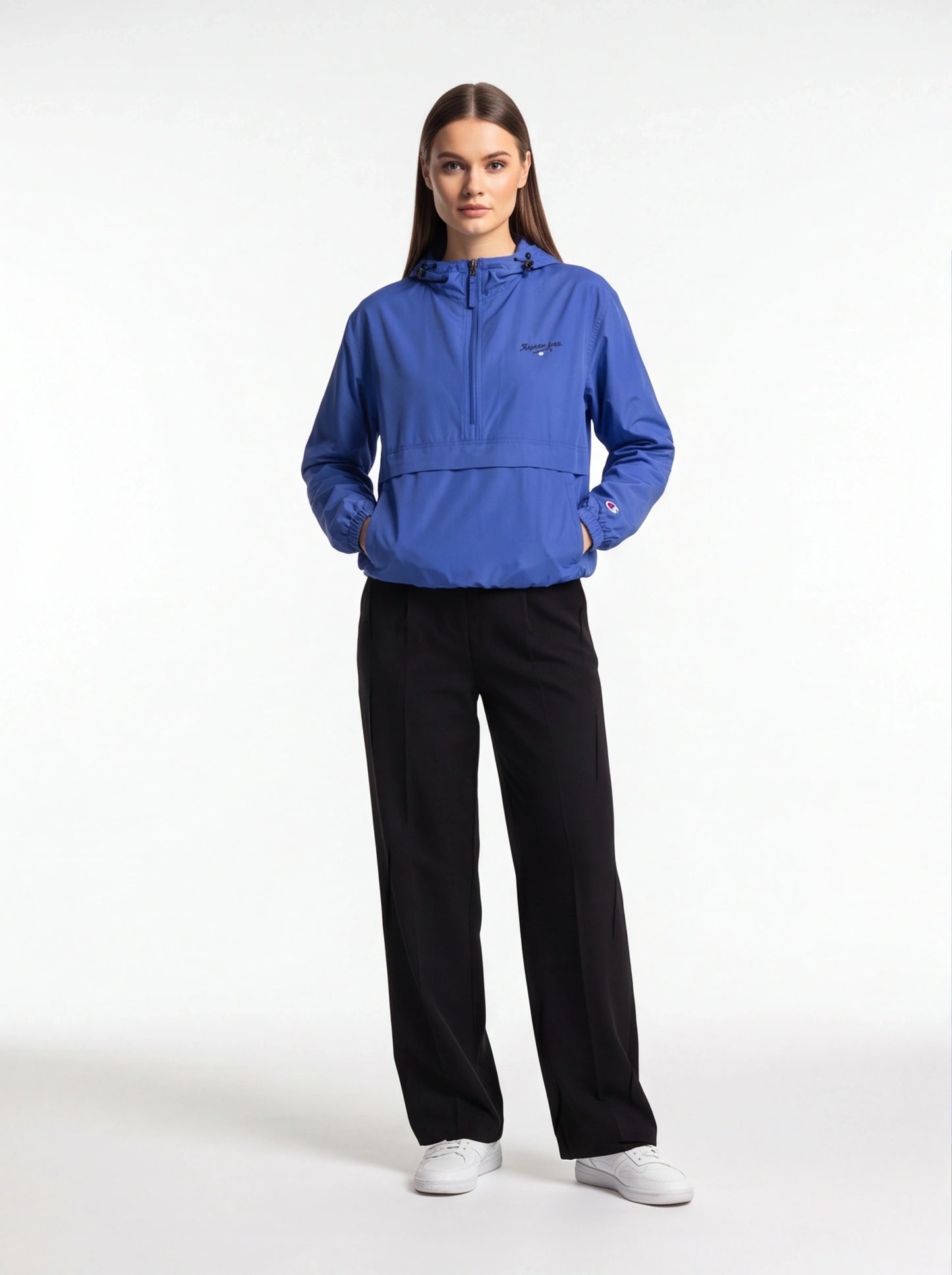 Woman wearing a blue jacket and black pants on a white background